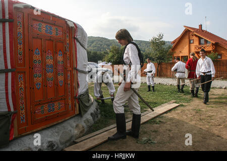 Campul Cetatii, Mures county, Romania, September 26, 2009: Youngsters dressed in traditional costumes are seen in a camp with traditional Mongolian yu Stock Photo