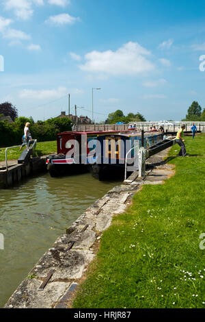 Devizes, Wiltshire, UK - 29th May 2016: Late spring sunshine brings visitors to look on as two canal narrow boats pass through a lock on the Kennet and Avon Canal in Devizes. The canal was restored in stages, largely by volunteers. After decades of dereliction it was fully reopened in 1990. The Kennet and Avon Canal is now a popular heritage tourism destination. Stock Photo