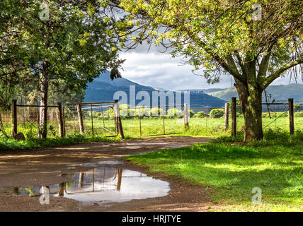 Rural landscape with sun breaking though after the rain with hills and cloudsky in background Stock Photo