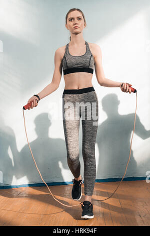 athletic young woman in sportswear exercising with skipping rope Stock Photo