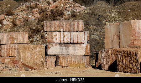 large marble quarry without people with the huge blocks of red marble extracted from the mountain Stock Photo