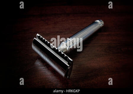 A silver Double Edge Safety Razor on a wooden table Stock Photo
