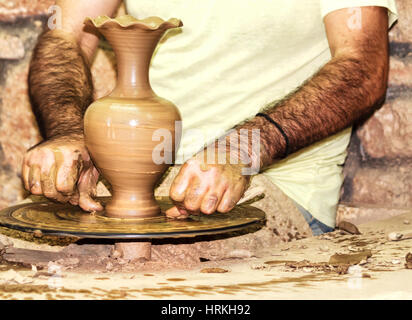 Man´s hands forming clay vase on the pottery wheel Stock Photo