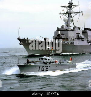 AJAXNETPHOTO. 23RD AUGUST, 2001. PORTSMOUTH, ENGLAND. - VINTAGE WELCOME - THE US NAVY'S NEWEST WARSHIP, THE ARLEIGH BURKE DESTROYER  USS WINSTON S. CHURCHILL ARRIVED AT PORTSMOUTH TODAY AT THE END OF HER MAIDEN FOREIGN VOYAGE, ONE OF THE CRAFT TO WELCOME THE SHIP WAS THE 64 YEAR OLD VOSPER BUILT MTB 102. FAMOUS FOR ITS ROLE AS THE PLATFORM USED TO CARRY THE US NAVY SHIP'S NAMESAKE WINSTON CHURCHILL AND GENERAL EISENHOWER ON THEIR INSPECTION OF THE D-DAY FLEET IN 1944, FOR ITS PART IN THE MOVIE, 'THE EAGLE HAS LANDED' AND AS A SEA SCOUT TRAINING VESSEL.PHOTO:JONATHAN EASTLAND/AJAX.  REF: 12308  Stock Photo