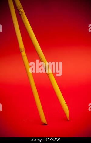 two sticks of bamboo on a red background Stock Photo