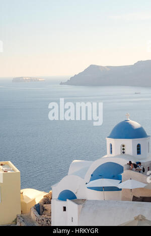 Beautiful domed church and the volcanic caldera with ships in the distance, sunset, Fira, Santorini - Thira, Cyclades islands, Greece Stock Photo