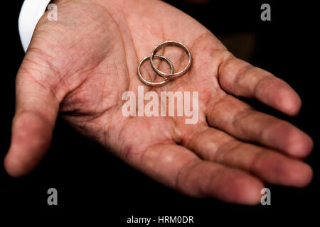 Wedding rings held by the groom Stock Photo