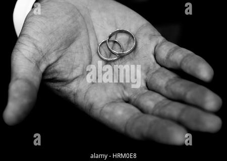 Wedding rings held by the groom Stock Photo