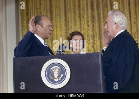 GERALD FORD (1913-2006) is sworn in as 38th President of the United States in the White House East Room by Chief Justice Warren Burger watched by Betty Ford on 9 August 1974 Stock Photo