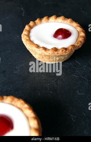 Cherry bakewell tarts on dark background Stock Photo