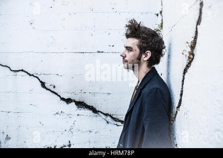 A profile portrait of a slightly disheveled looking young man. Stock Photo