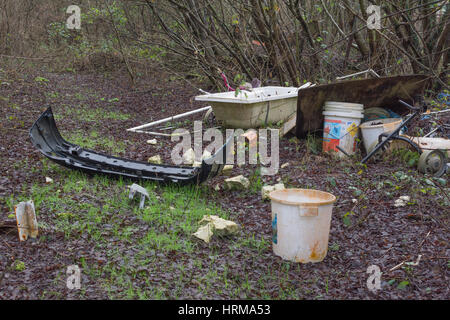 Domestic rubbish fly-tipped in a corner of woodland. An example of environmental pollution, fly tipping. Stock Photo