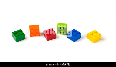 Green, orange, red, blue, yellow Lego bricks or pieces 2 by 2, 2x2 on white. Stock Photo