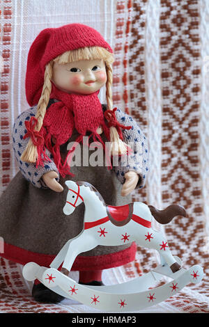 little puppets in national traditional  folklore dress Finland standing beside rocking horse Stock Photo