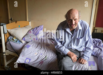 Bedridden man living alone in social housing Stock Photo