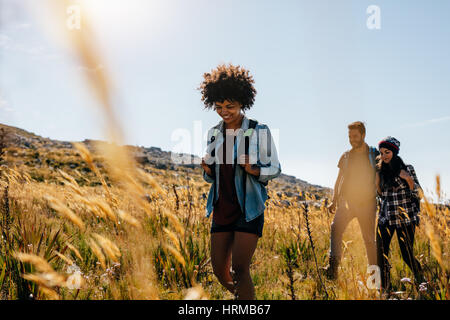 Group of people hiking in countryside. Young women and men on mountain hike. Stock Photo