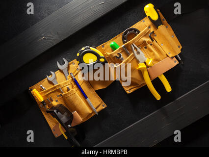 tools and instruments in belt on black background Stock Photo