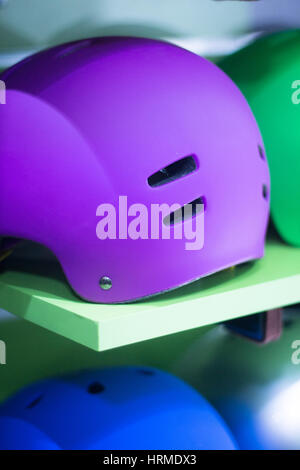 Inline and quad roller skates helmets head protection in retail skate shop display on sale. Stock Photo