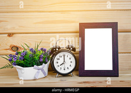 Blank wood photo frame and alarm clock with flower on wooden room, Save clipping path. Stock Photo