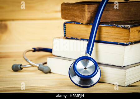 Stethoscope and old books on wooden background. Stock Photo