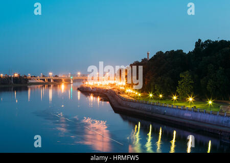 The Scenic Summer Evening View Of Sozh River, Illuminated Embankment And Ancient Greenwood Park In Gomel, Homiel, Belarus. Blue Sky Background. Stock Photo
