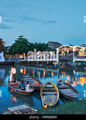 Boats on Thu Bon River and Cau An Hoi Bridge illuminated at night. Hoi An Ancient Town, Quang Nam Province, Vietnam. Stock Photo