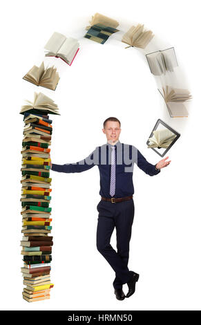 Young student telling about education process and stands in free pose beside pile of books, from which moving to tablet device. Progress of process of Stock Photo