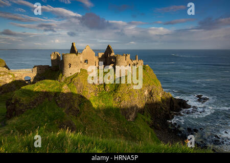 Sunrise over Dunluce Castle along northern coast of County Antrim, Northern Ireland, UK Stock Photo