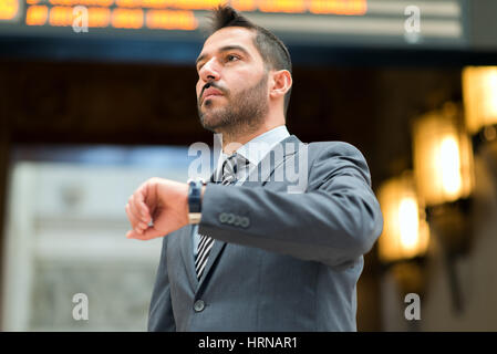 Man checking time in front of a timetable Stock Photo