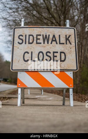 Low Angle View of Dirty Sidewalk Closed Sign on city street Stock Photo