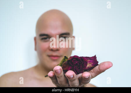 Closeup of a man giving old red flowers Stock Photo
