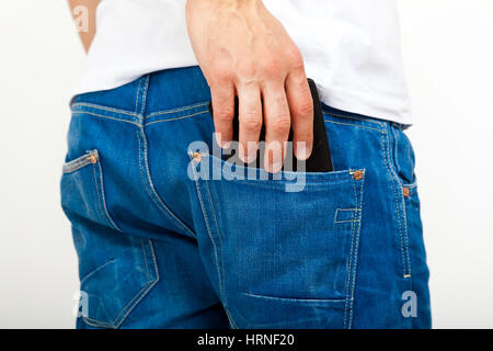 Young man extracting a wallet from his blue jeans isolated on white Stock Photo