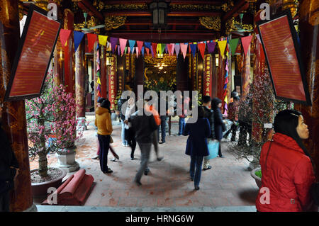 HANOI, VIETNAM - FEBRUARY 19, 2013: Buddhist worshippers praying in the interior of Bac Ma temple in Hanoi Vietnam Stock Photo