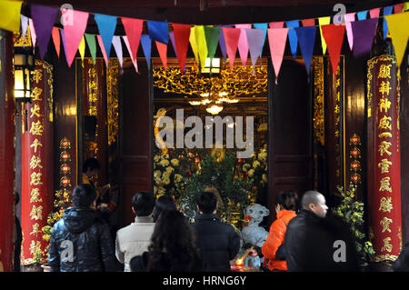 HANOI, VIETNAM - FEBRUARY 19, 2013: Buddhist worshippers praying in the interior of Bac Ma temple in Hanoi Vietnam Stock Photo