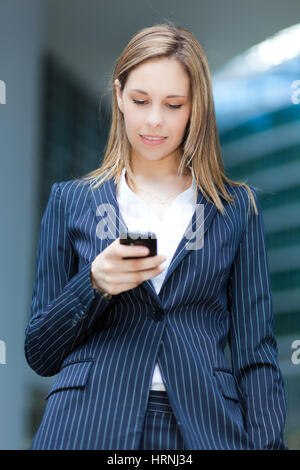 Businesswoman sending a sms Stock Photo