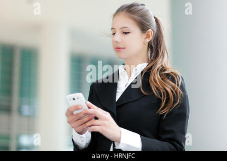 Businesswoman sending a sms outdoor Stock Photo