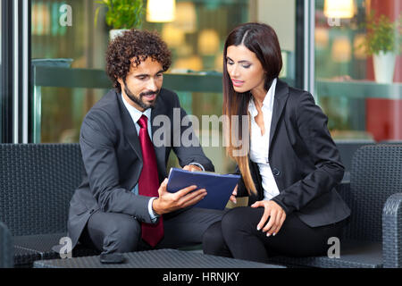 Two business people sitting outdoor Stock Photo