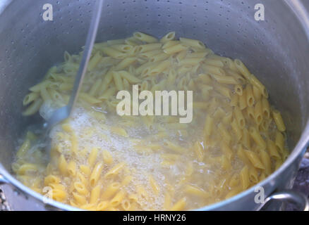 pasta called MEZZE PENNE in Italy cooked in the boiling water in large pot of Italian restaurant Stock Photo