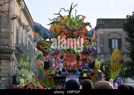 Acireale (CT), Italy - February 28, 2017: allegorical float, depicting a large head and other characters in vegetable's shape, during carnival parade Stock Photo