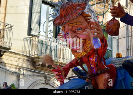 Acireale (CT), Italy - February 28, 2017: detail of a allegorical float, depicting a man with dress and red hat, during the carnival parade Stock Photo