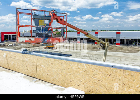 Cherry picker has elevated platform to riggers get high in safety basket on edifice roof. Nobody, empty Stock Photo