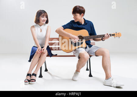 Young man playing guitar for his girlfriend Stock Photo