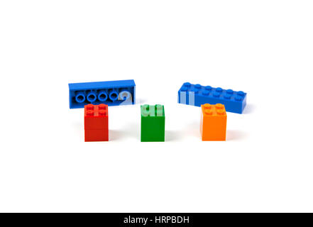 Lego bricks or pieces ready to be mounted on three piers to form a model of a bridge or viaduct. Stock Photo