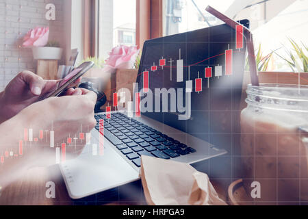 Businessman is working with his computer in coffee shop with stock chart and data overlay Stock Photo