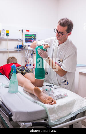 Doctor placing a plaster , emergency department of a private hospital . Stock Photo