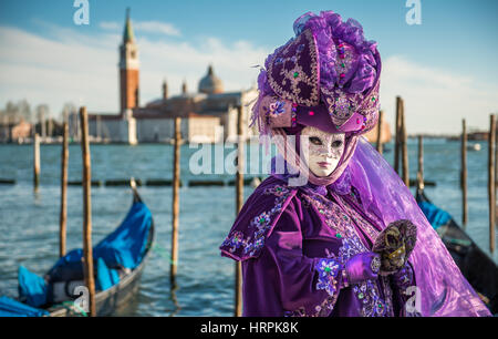 Golden Venetian Carnival Mask. Wonderful mask participant of the carnival celebrations in St. Mark's basin. Blurred background. Stock Photo