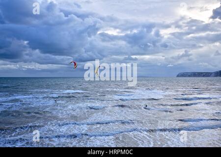 Kite surfers on a windy day with a stormy sky Compton Bay, Isle of Wight Stock Photo