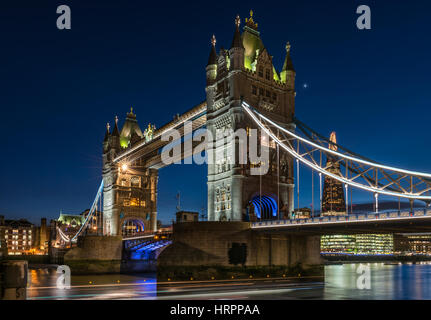 The lights come on at dusk on Tower Bridge on a calm but cold night in the capital city of London.
