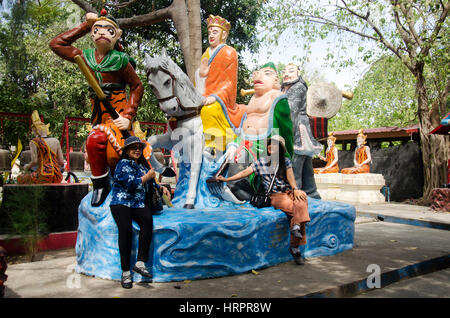 Thai woman sit and posing for take photo with Journey to the West statue at Wat Muang temple on January 25, 2017 in Ang Thong, Thailand