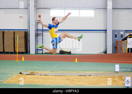 SUMY, UKRAINE - FEBRUARY 17, 2017: Serhiy Nykyforov performing his long jump in qualification on Ukrainian indoor track and field championship 2017. Stock Photo